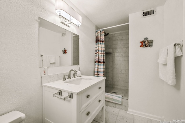 bathroom with a shower stall, vanity, toilet, marble finish floor, and visible vents