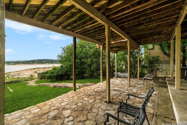view of patio / terrace featuring fence and a water view