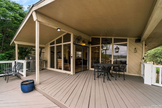 wooden terrace featuring area for grilling and outdoor dining area