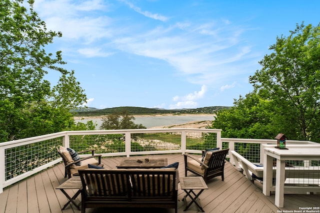 wooden terrace featuring outdoor lounge area and a water view