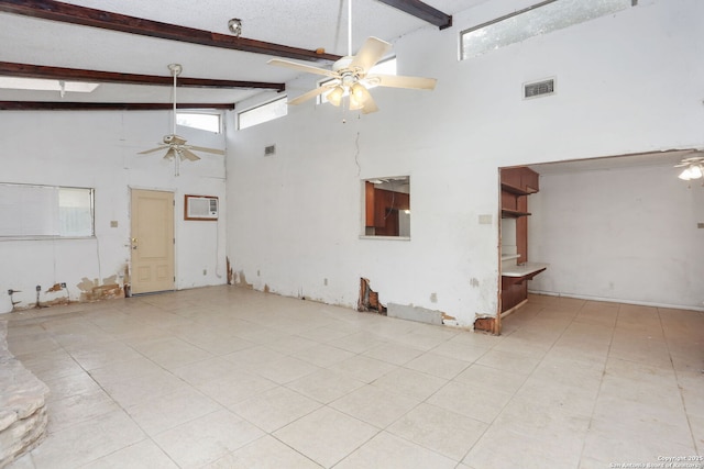 tiled empty room with beam ceiling, visible vents, ceiling fan, and a towering ceiling