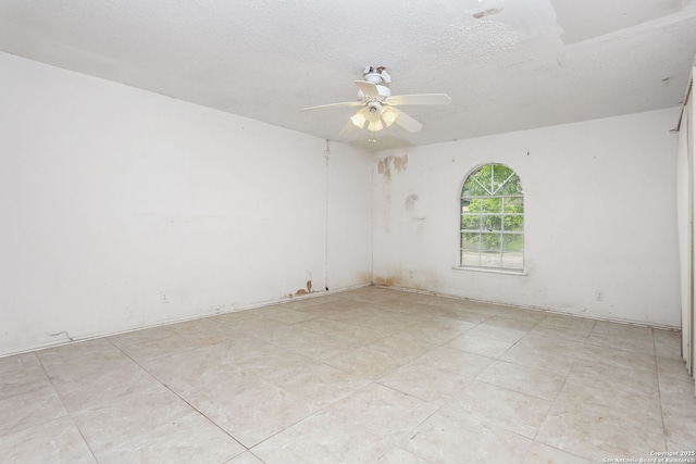 unfurnished room with a textured ceiling, ceiling fan, and light tile patterned floors