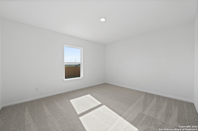carpeted spare room featuring baseboards
