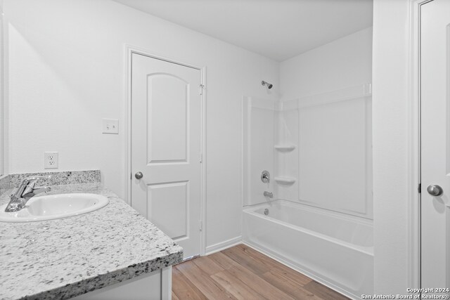 bathroom with wood finished floors, bathtub / shower combination, and vanity