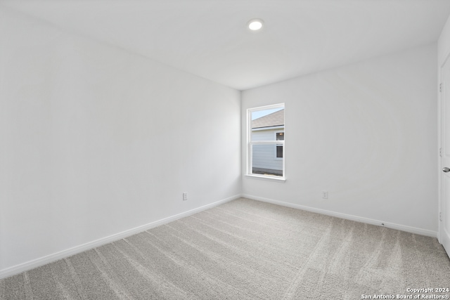 empty room with baseboards and light carpet