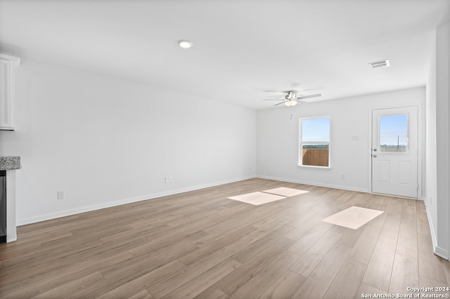 unfurnished living room featuring visible vents, ceiling fan, baseboards, and light wood-style floors