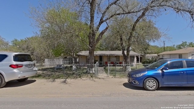 view of front facade with covered porch and a fenced front yard