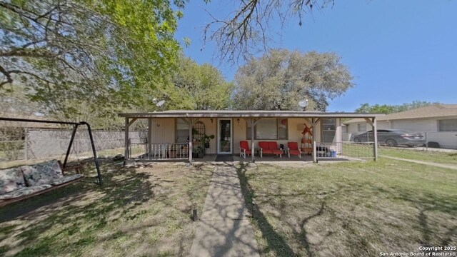back of property featuring fence, a yard, and a porch