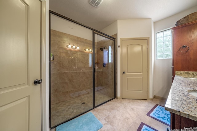 bathroom featuring visible vents, tile patterned floors, a stall shower, and vanity
