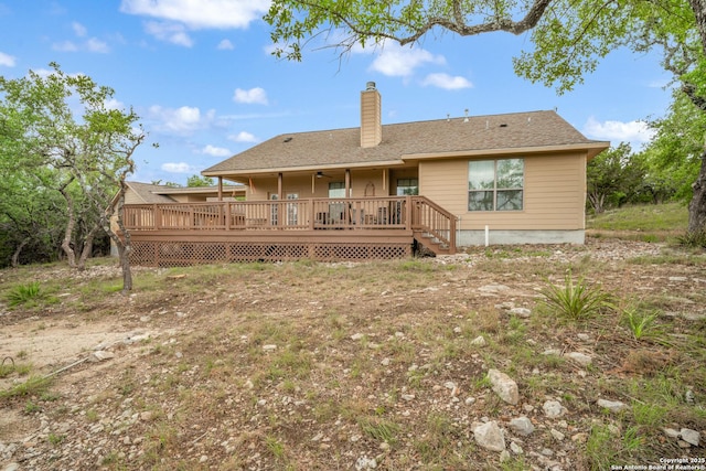 rear view of property featuring a ceiling fan, a chimney, and a deck