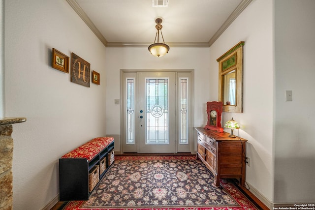 foyer entrance with baseboards, visible vents, and ornamental molding