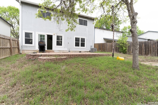 rear view of house featuring cooling unit, a lawn, a patio, and a fenced backyard