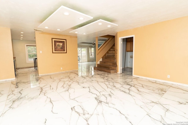 unfurnished living room featuring recessed lighting, marble finish floor, and a healthy amount of sunlight