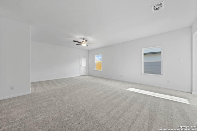 spare room with baseboards, visible vents, ceiling fan, and carpet
