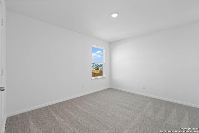 spare room with baseboards, recessed lighting, and carpet flooring