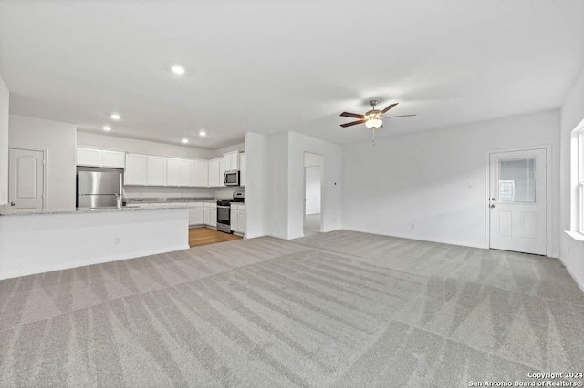 unfurnished living room with baseboards, recessed lighting, a ceiling fan, and light colored carpet