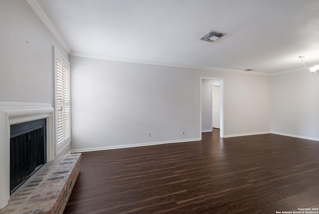 unfurnished living room featuring wood finished floors, visible vents, ornamental molding, and a brick fireplace