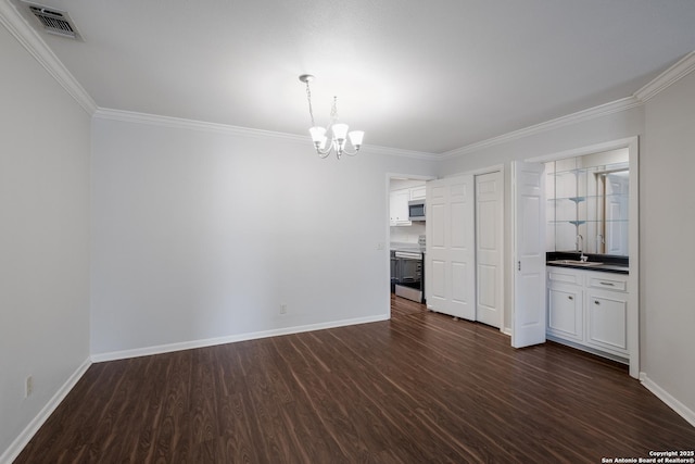unfurnished dining area with an inviting chandelier, ornamental molding, dark wood finished floors, and a sink