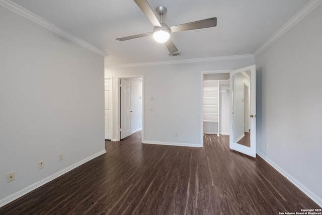 unfurnished room featuring dark wood-type flooring, baseboards, ceiling fan, and crown molding