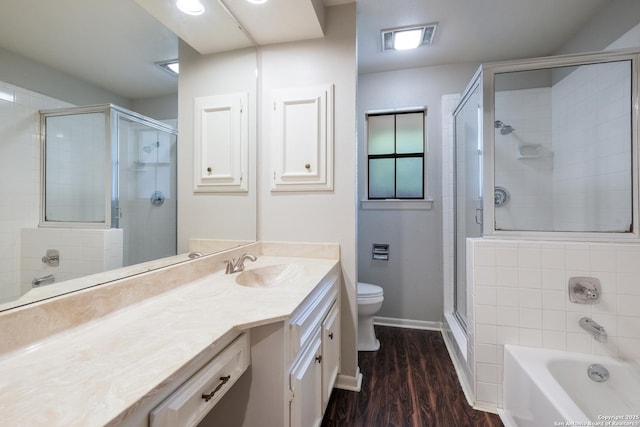 bathroom featuring a stall shower, toilet, a bath, wood finished floors, and vanity