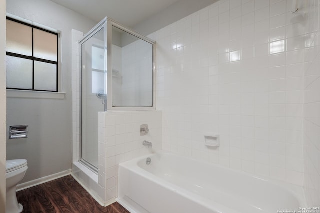bathroom featuring a shower stall, a tub to relax in, toilet, baseboards, and wood finished floors