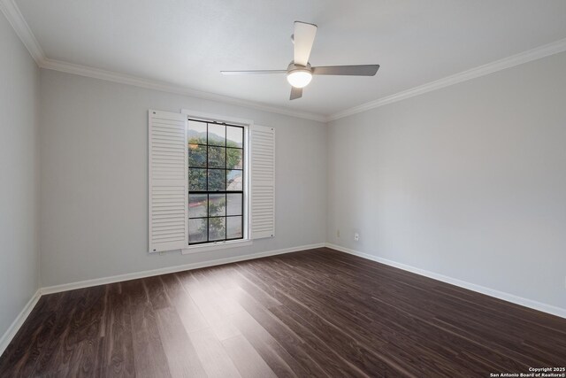 empty room with ornamental molding, dark wood-style flooring, and baseboards