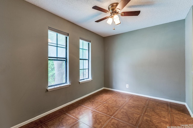 unfurnished room featuring a textured ceiling, ceiling fan, and baseboards
