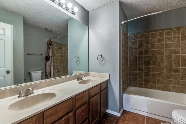 full bath featuring toilet, a textured ceiling, and a sink