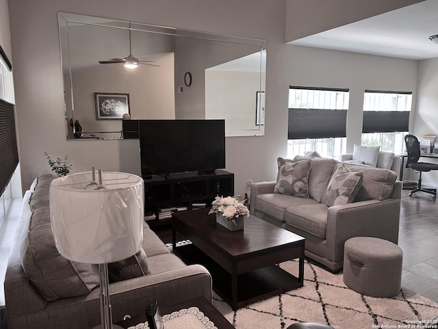 living area with a ceiling fan and wood finished floors