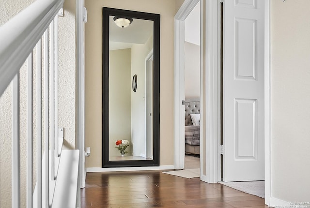 hallway with baseboards and wood finished floors