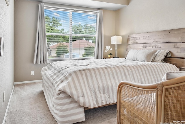 bedroom with baseboards and carpet