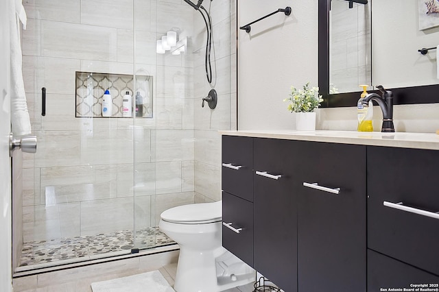 bathroom with vanity, a stall shower, and toilet