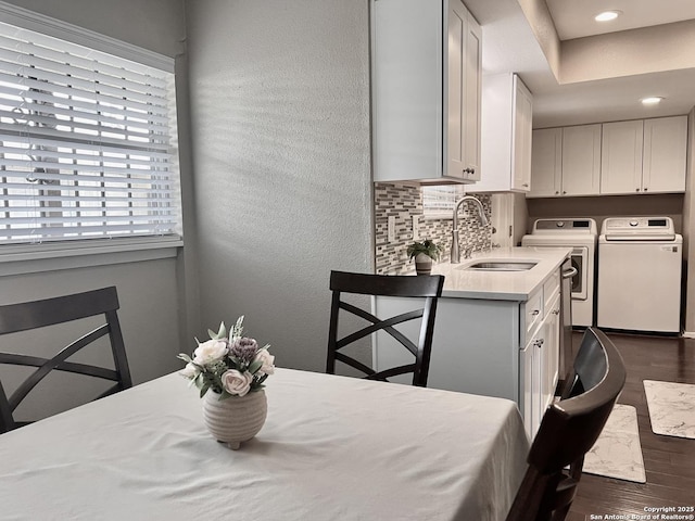 dining space featuring dark wood-type flooring, recessed lighting, a textured wall, and washing machine and dryer