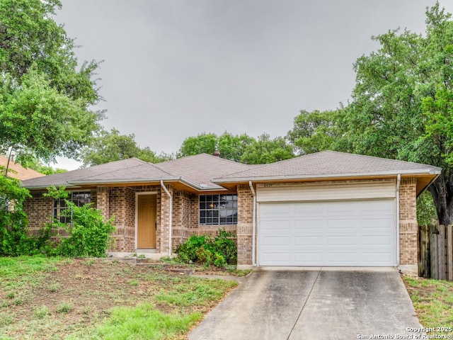 single story home with fence, concrete driveway, brick siding, and a garage