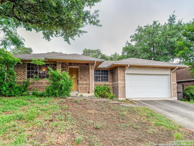 single story home featuring concrete driveway, an attached garage, and brick siding