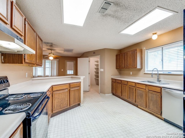 kitchen featuring under cabinet range hood, a sink, visible vents, black range with electric cooktop, and dishwashing machine