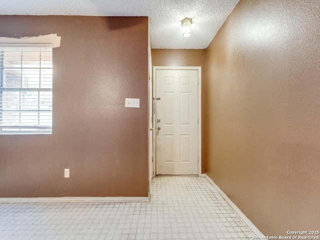interior space featuring tile patterned floors, a wealth of natural light, and baseboards