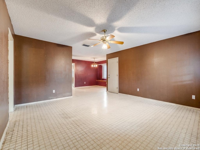 unfurnished room with light floors, ceiling fan with notable chandelier, baseboards, visible vents, and a textured ceiling