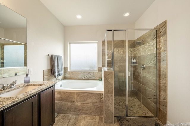 full bath with a stall shower, a bath, and vanity