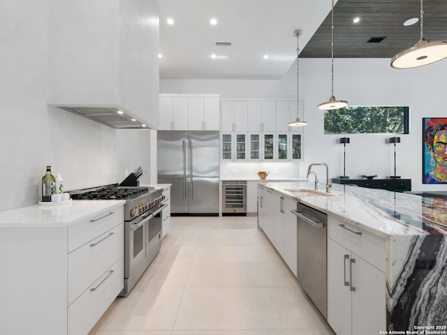kitchen with beverage cooler, premium appliances, modern cabinets, and a sink