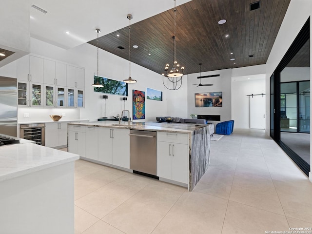 kitchen featuring visible vents, stainless steel appliances, wine cooler, and a towering ceiling