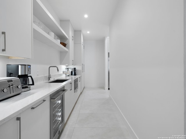 kitchen with light tile patterned floors, white cabinetry, open shelves, a sink, and wine cooler