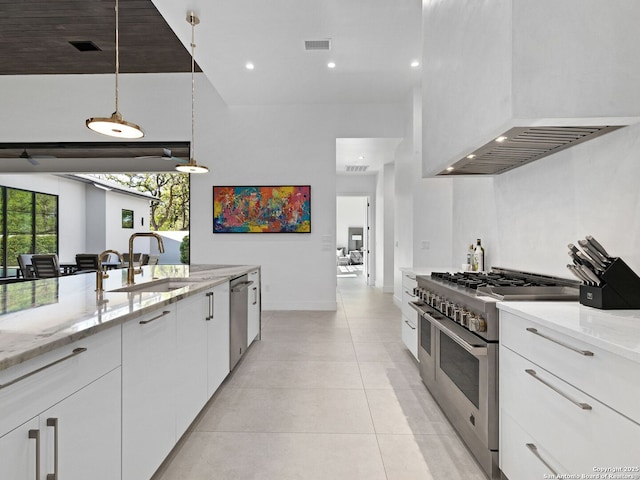 kitchen featuring a sink, stainless steel appliances, wall chimney exhaust hood, visible vents, and white cabinets