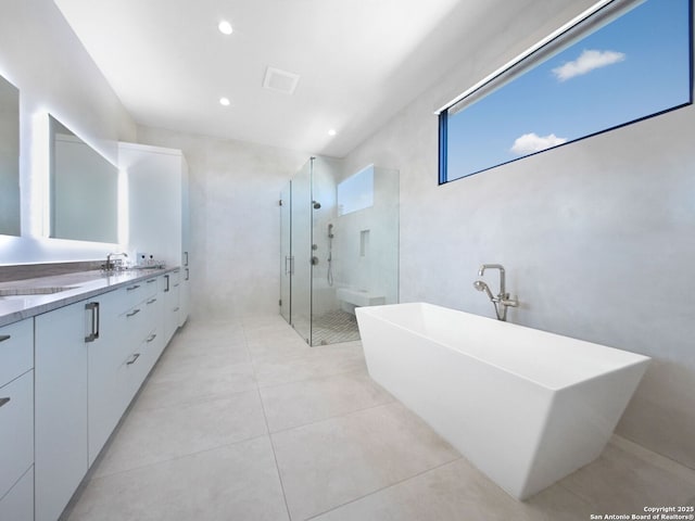 full bath with a soaking tub, double vanity, a stall shower, recessed lighting, and tile patterned floors