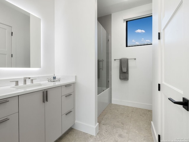 full bath featuring baseboards, tile patterned floors, bath / shower combo with glass door, and vanity