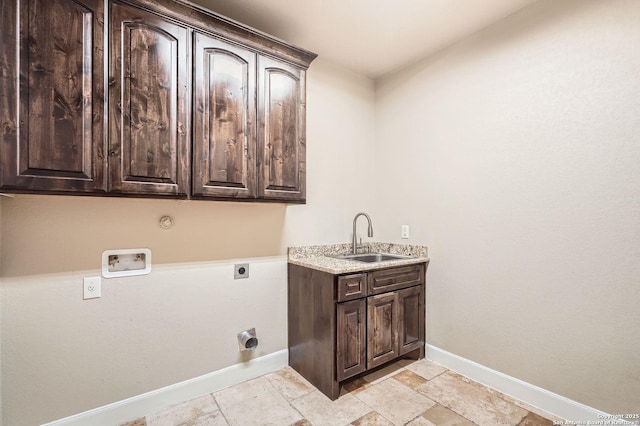 washroom with hookup for a washing machine, electric dryer hookup, cabinet space, a sink, and baseboards