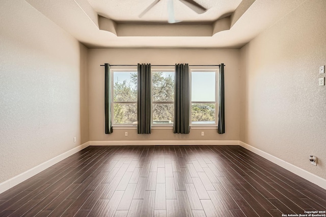 spare room with a wealth of natural light and dark wood-type flooring