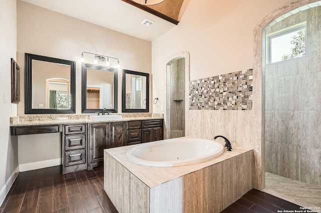 bathroom featuring visible vents, wood finished floors, vanity, and a jetted tub