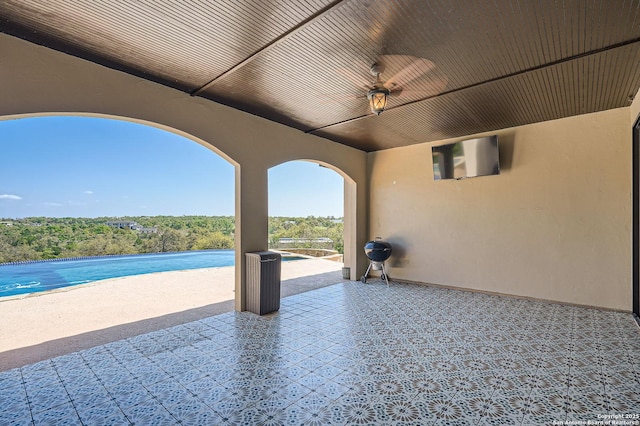 view of patio featuring ceiling fan and an outdoor pool
