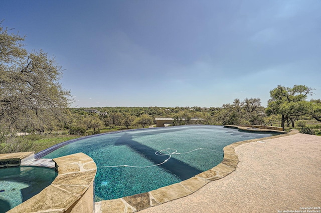 view of swimming pool with a pool with connected hot tub